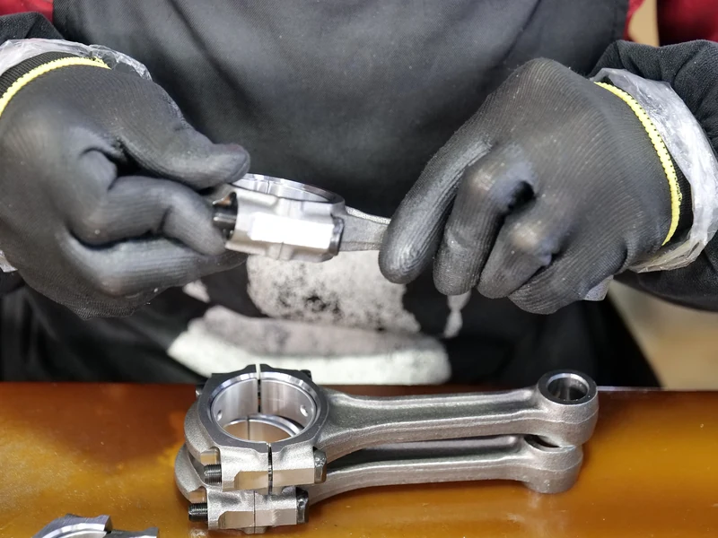 Engineer inspecting a precision machined metal component during structural optimization review